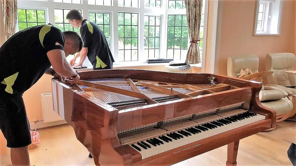 777 World Removals crew wrapping a grand piano