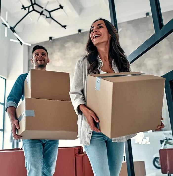 Couple moving boxes into their new Sydney home